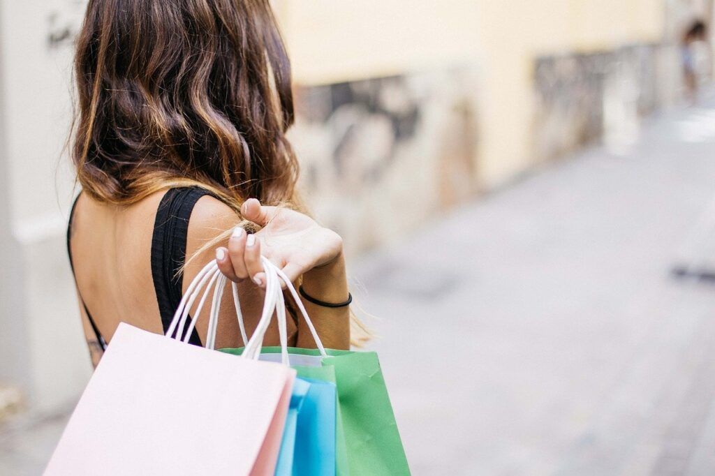 A woman holding many shopping bags over her shoulder - One Salonica is an outlet shopping mall in Thessaloniki