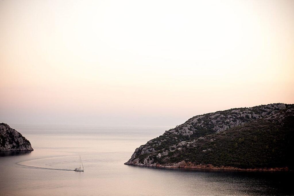 Beaches of Sithonia - A fishing boat enters Porto Koufo, Greece's largest natural harbor